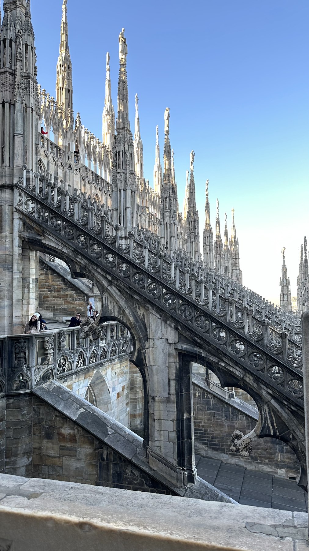 Arco rampante in marmo e decorazioni scolpite sulle terrazze del Duomo