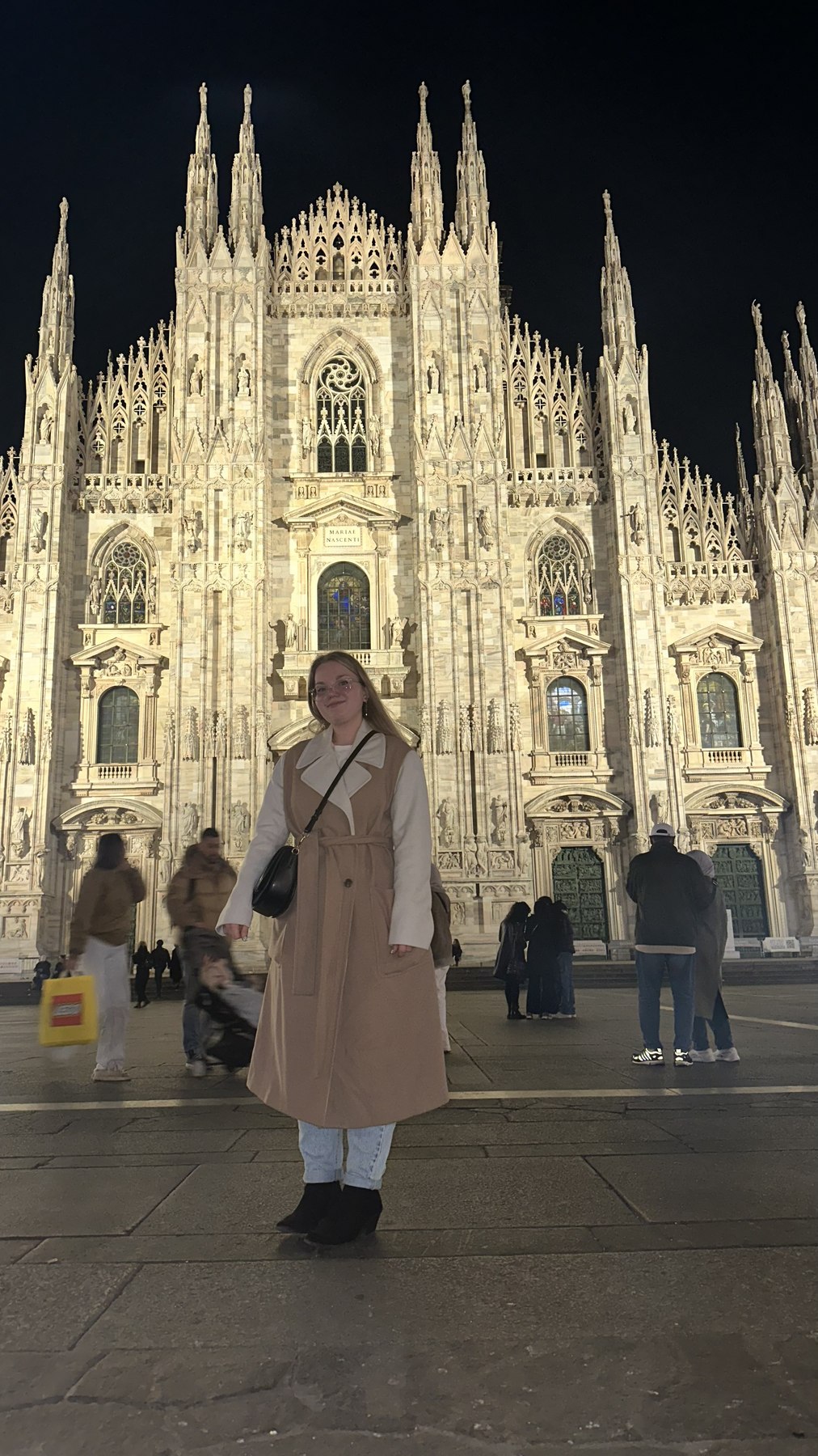 Viaggiatrice davanti al Duomo di Milano di sera